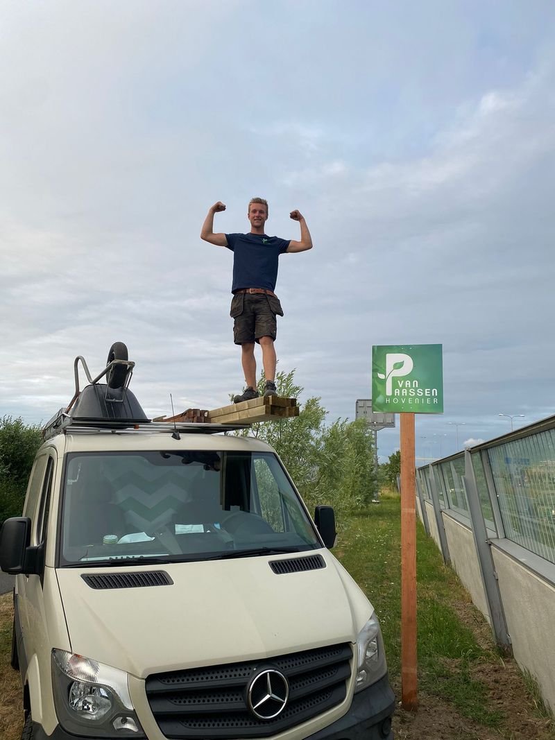 Milo van Paassen bij de bedrijfsbus van Van Paassen Hovenier